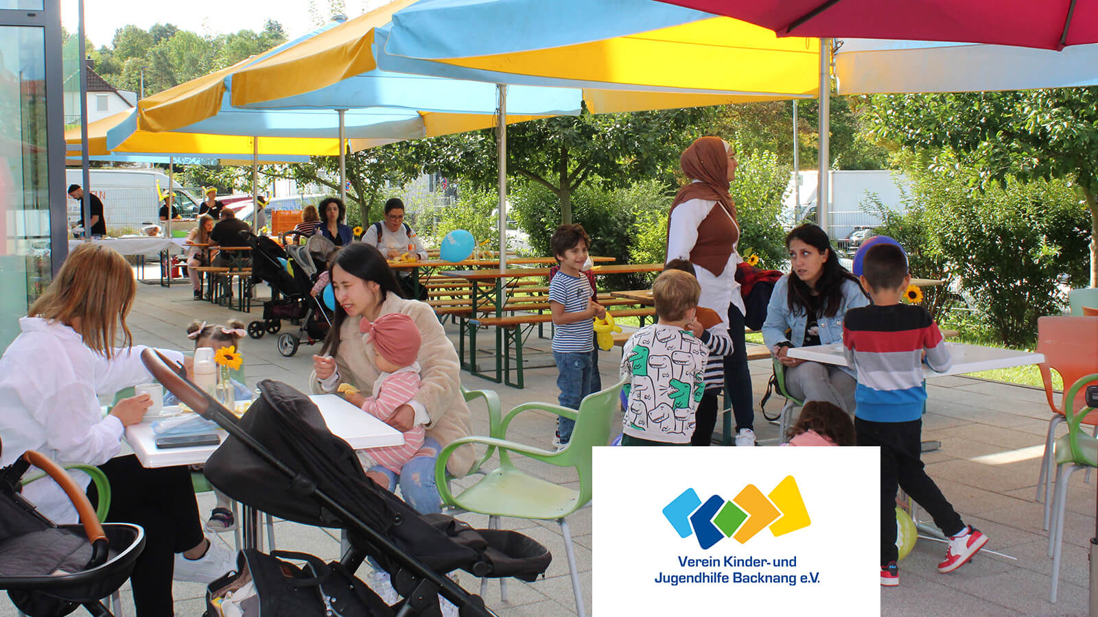 Gartenfest im Sommer unter Sonnenschirmen | Kinder- und Jugendhilfe Backnang e.V.