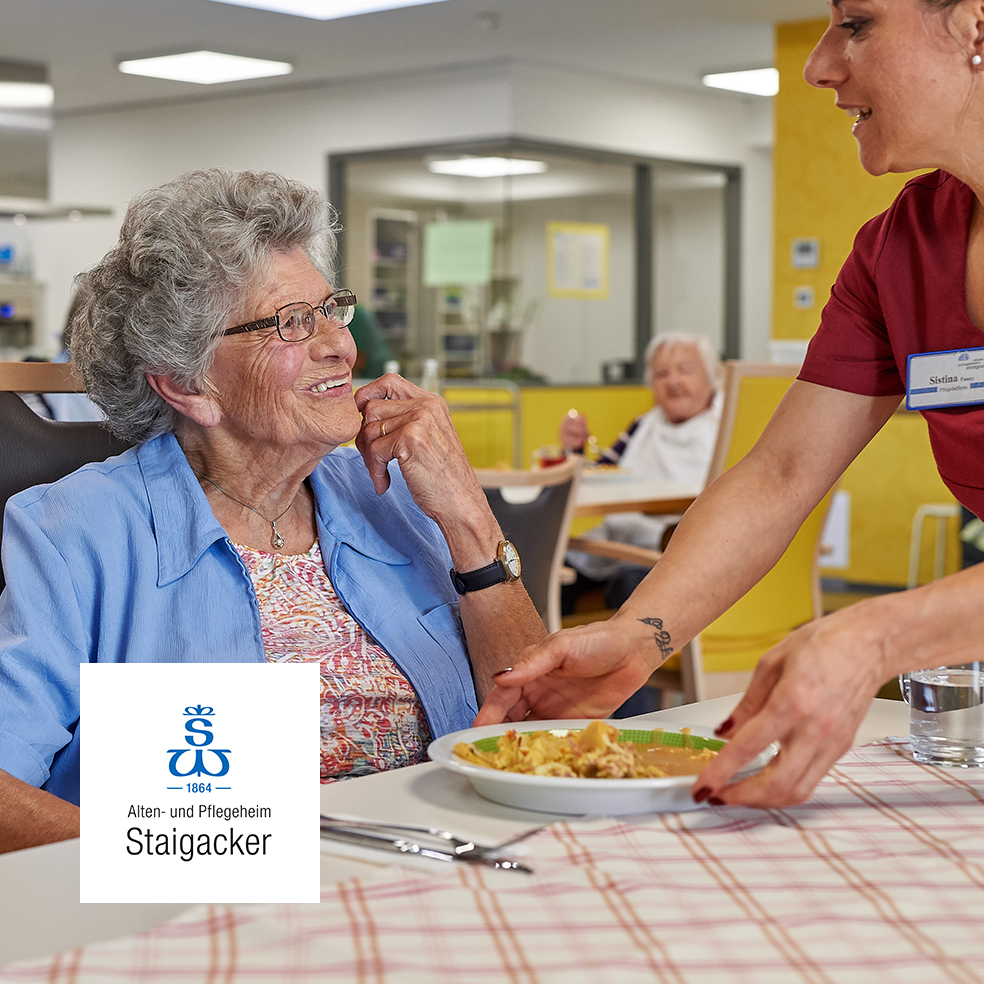 Pflegekraft serviert Mahlzeit – wertschätzende Seniorenbetreuung im Alten- und Pflegeheim Staigacker.